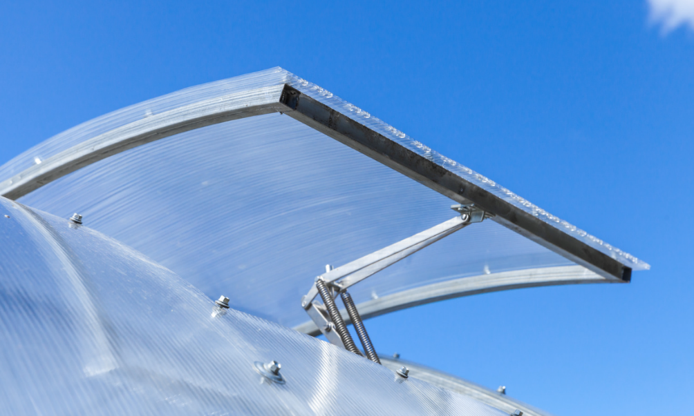 A modern polycarbonate greenhouse with an automatic polycarbonate rooftop window