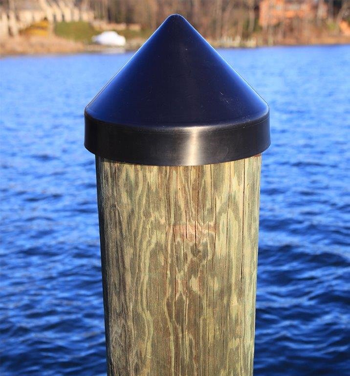 Black piling cap on the wooden post of a pier